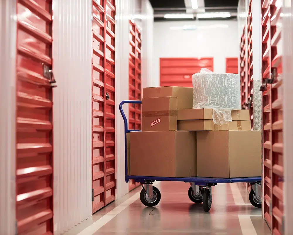 Cartons en entrepôt de stockage | ON TIME GROUPE Chariot avec cartons dans un entrepôt de stockage